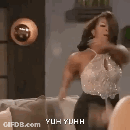 A Woman Is Dancing On A Couch In A Living Room With A Lamp In The Background . GIF