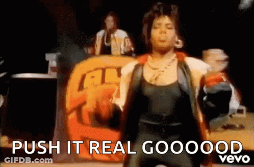 A Woman Is Dancing On A Stage In Front Of A Sign That Says Push It Real Goooood Vevo . GIF