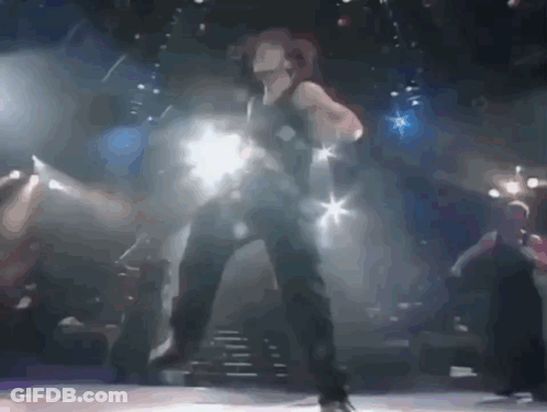 A Woman Is Dancing On A Stage With A Blurred Background GIF