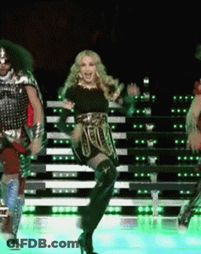A Woman Is Dancing On A Stage With A Man In Armor GIF
