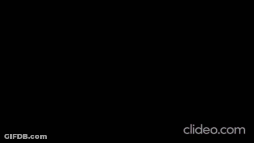 A Woman Is Dancing On A Stage With A Microphone . GIF