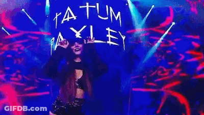 A Woman Is Dancing On A Stage With A Sign That Says Atum Ey . GIF