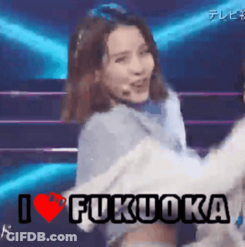 A Woman Is Dancing On A Stage With The Words I Love Fukuoka Written Above Her GIF