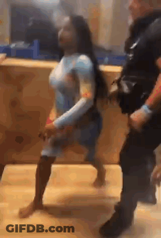 A Woman Is Dancing With A Police Officer In A Video . GIF