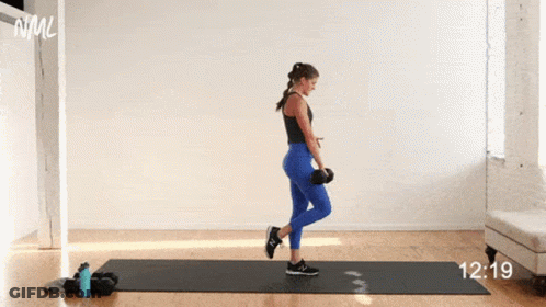 A Woman Is Doing A Balance Exercise With A Dumbbell On A Yoga Mat . GIF