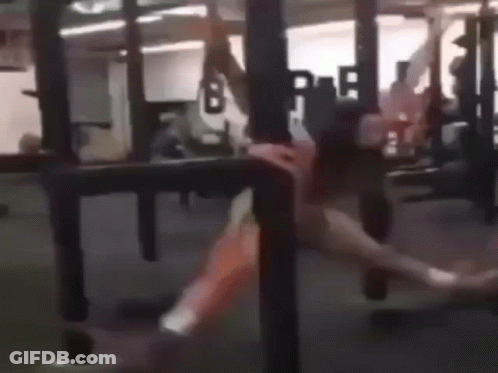 A Woman Is Doing A Handstand In A Gym . GIF