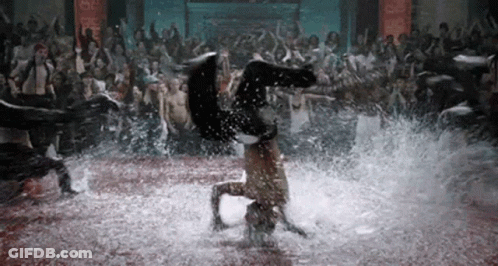 A Woman Is Doing A Handstand In The Water While A Crowd Of People Watch . GIF