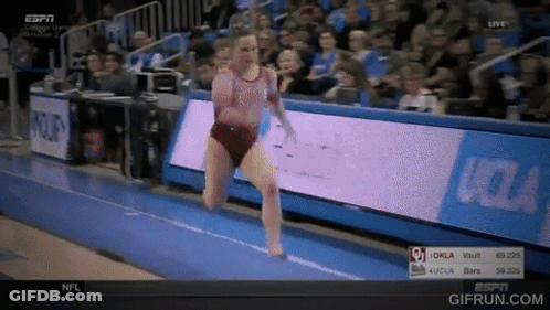 A Woman Is Doing A Trick On A Trampoline In Front Of A Sign That Says Oklahoma GIF