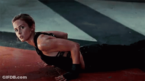 A Woman Is Doing Push Ups On The Floor In A Dark Room . GIF