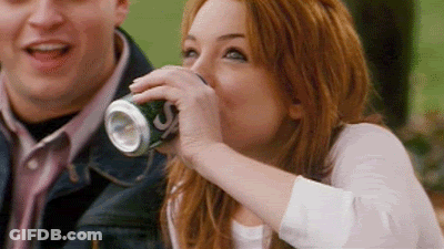 A Woman Is Drinking A Can Of Soda From A Can . GIF