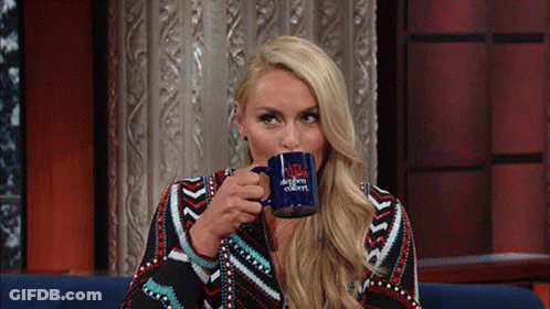 A Woman Is Drinking From A Blue Mug That Says The Tonight Show With Jimmy Fallon GIF