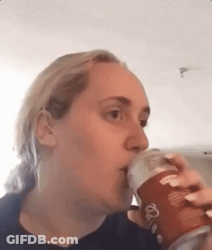 A Woman Is Drinking From A Can Of Pringles . GIF