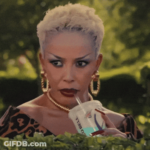 A Woman Is Drinking From A Cup That Says O Bell GIF
