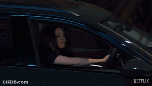A Woman Is Driving A Car With Netflix Written On The Bottom Right GIF