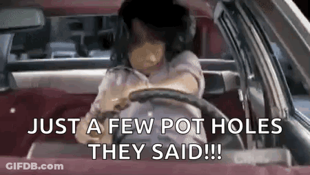 A Woman Is Driving A Car With The Words `` Just A Few Pot Holes They Said '' Written On The Screen . GIF