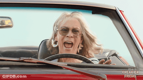 A Woman Is Driving A Red Car With The Words Freakier Friday Written On The Side GIF