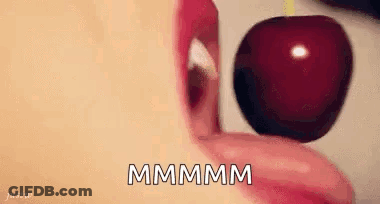 A Woman Is Eating A Cherry With Her Tongue . GIF