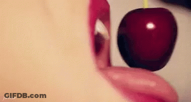 A Woman Is Eating A Cherry With Her Tongue . GIF