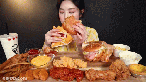 A Woman Is Eating A Hamburger With A Kfc Drink GIF