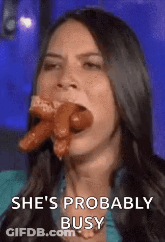 A Woman Is Eating A Hot Dog With The Words `` She 'S Probably Busy '' Written Below Her . GIF