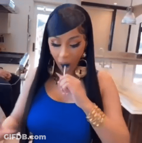 A Woman Is Eating A Lollipop In A Kitchen . GIF