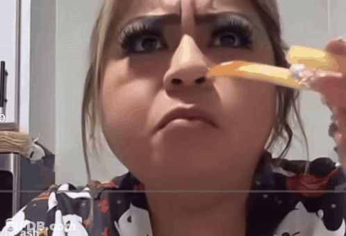 A Woman Is Eating French Fries And Making A Funny Face In Front Of A Screen That Says Ash GIF