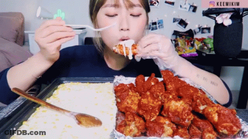 A Woman Is Eating Fried Chicken With A Fork And The Word Keemikim Is On The Bottom Right GIF