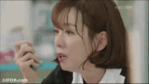 A Woman Is Eating Something With A Spoon And A Fork . GIF