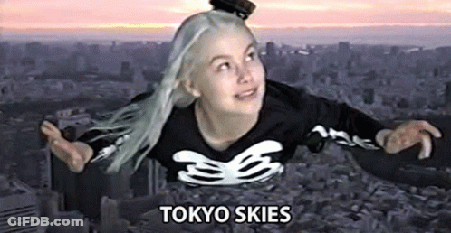 A Woman Is Flying Through The Air In A Tokyo Skies Shirt . GIF