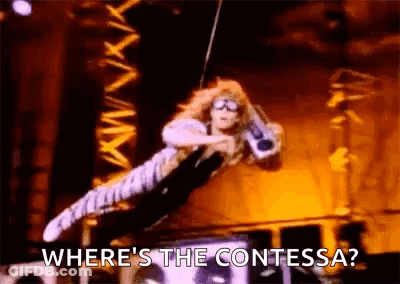 A Woman Is Flying Through The Air While Holding A Microphone And Says `` Where 'S The Contessa ? '' GIF