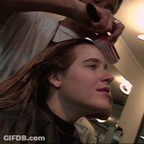 A Woman Is Getting Her Hair Brushed By A Hairdresser GIF