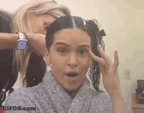 A Woman Is Getting Her Hair Cut By A Hairdresser While Another Woman Looks On . GIF