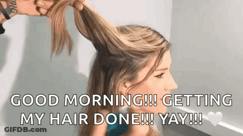 A Woman Is Getting Her Hair Done By A Hairdresser In A Room . GIF