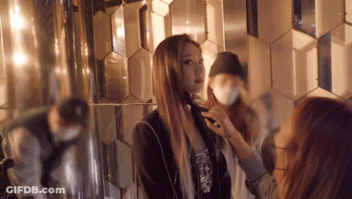 A Woman Is Getting Her Hair Done In Front Of A Mirror While Another Woman Looks On GIF