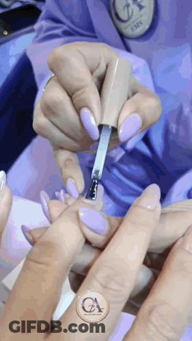 A Woman Is Getting Her Nails Painted By A Nail Technician With A Logo That Says Ca GIF