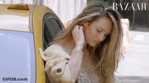 A Woman Is Getting Out Of A Taxi With A Harper 'S Bazaar Logo Behind Her GIF