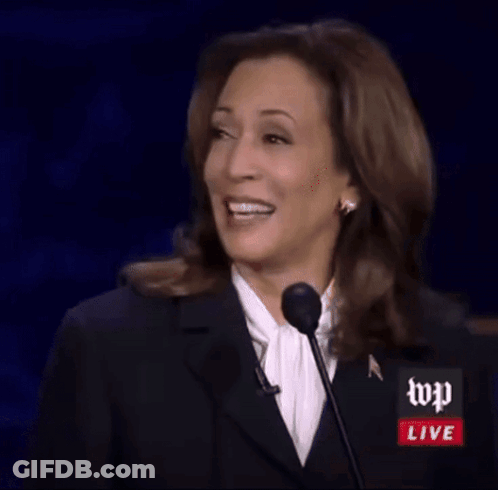 A Woman Is Giving A Speech In Front Of A Microphone With Wp Live Written On It GIF