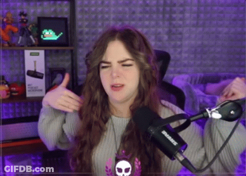 A Woman Is Giving A Thumbs Up In Front Of A Microphone That Says Shure GIF