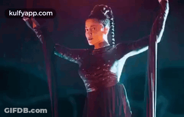 A Woman Is Hanging From A Rope In A Dark Room . GIF