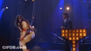 A Woman Is Hanging From A Rope In Front Of A Cross That Is On Fire . GIF
