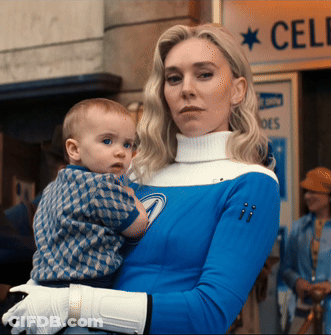 A Woman Is Holding A Baby In Front Of A Sign That Says Cele GIF