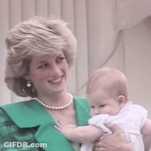 A Woman Is Holding A Baby In Her Arms And Smiling . GIF