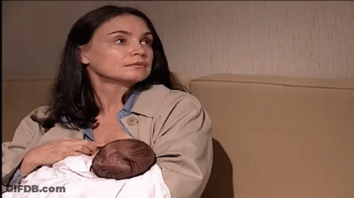 A Woman Is Holding A Baby In Her Arms GIF