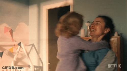A Woman Is Holding A Baby In Her Arms With Netflix Written On The Bottom Of The Screen GIF