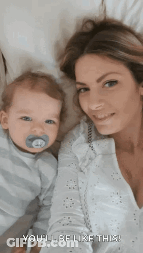 A Woman Is Holding A Baby With A Pacifier In His Mouth And Says " You 'Ll Be Like This " . GIF