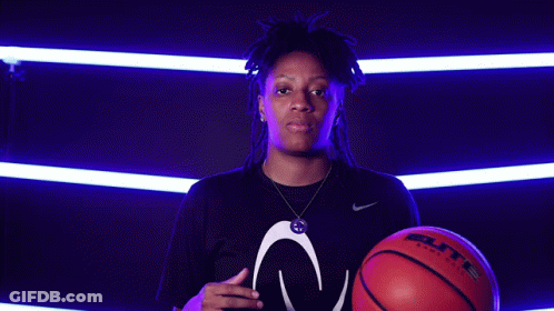 A Woman Is Holding A Baden Basketball In Her Hand GIF