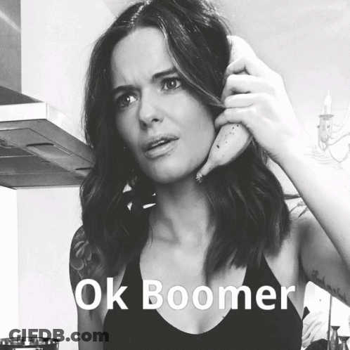 A Woman Is Holding A Banana To Her Ear With The Words Ok Boomer Written Below Her GIF