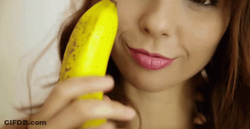 A Woman Is Holding A Banana To Her Face GIF