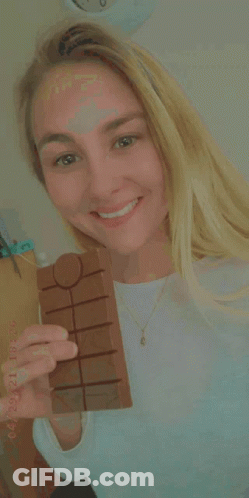 A Woman Is Holding A Bar Of Chocolate In Her Hand With A Date Stamp Of 04/21 GIF
