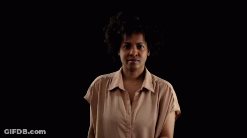 A Woman Is Holding A Bible In Front Of Her Face GIF